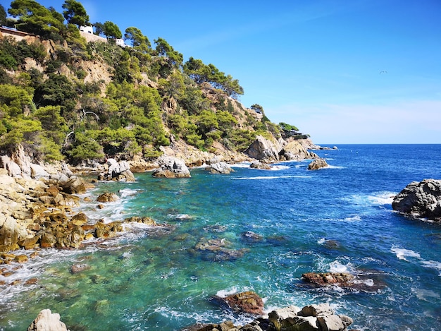 Foto panoramica della costa rocciosa con il cielo con piante verdi alberi e case private la costa spagnola della costa brava il mar mediterraneo turismo vivere in un posto bellissimo