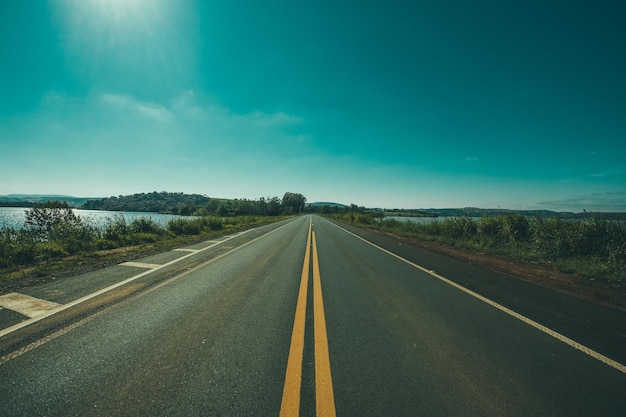 Photo panoramic photography of road between grasses and body of waters photo