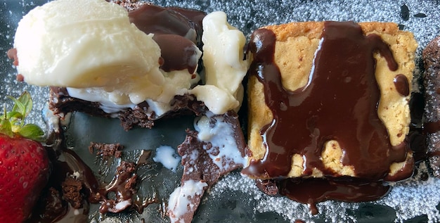 Photo panoramic picture of dark and white chocolate brownie and ice cream on a dish