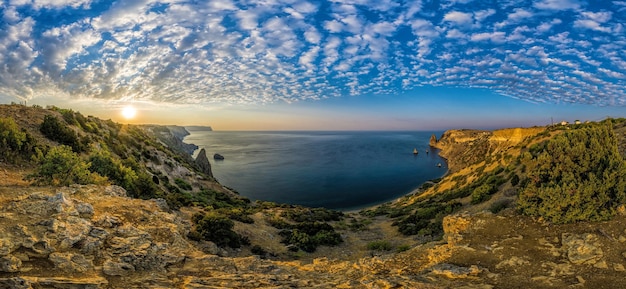 Panoramic seascape calm sea clouds and bright sunrise view of the black sea coast in crimea cape