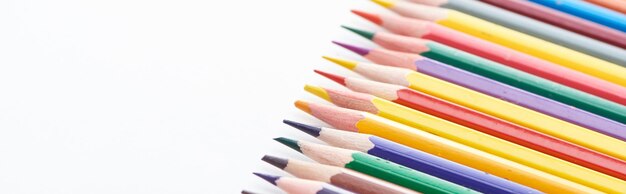 Panoramic shot of color pencils row isolated on white