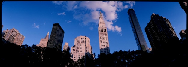 Photo panoramic shot of metropolitan life tower amidst buildings in city against blue sky