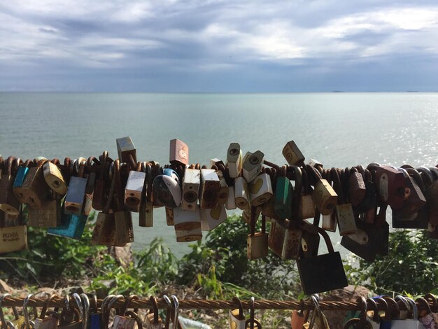 Panoramic shot of padlocks on sea against sky