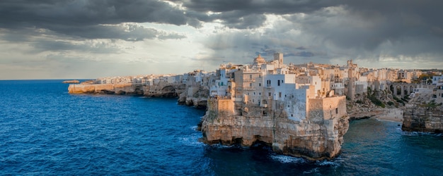 Scatto panoramico di polignano a mare circondato dal mare sotto un cielo tempestoso in italia