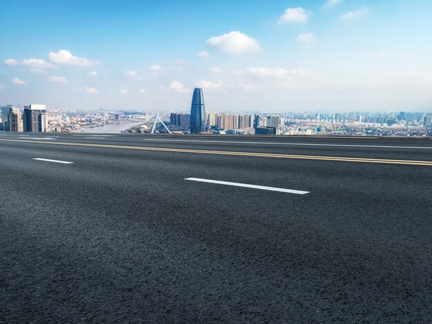 Panoramic skyline and empty asphalt road with modern buildings