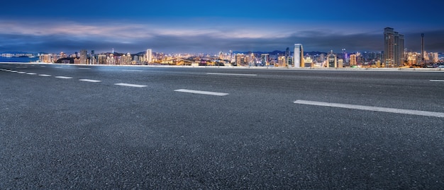 Panoramic skyline and empty asphalt road with modern buildings