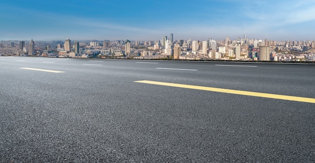 パノラマのスカイラインとモダンな建物のある空のアスファルト道路