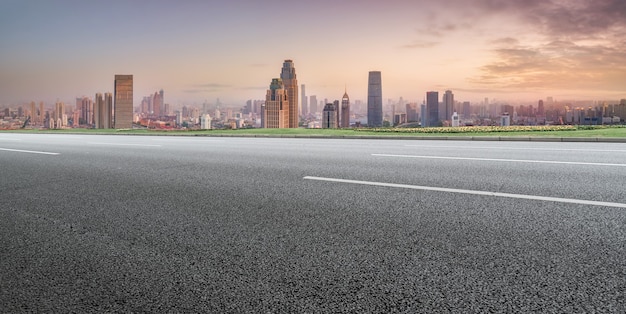 Panoramic skyline and empty asphalt road with modern buildings