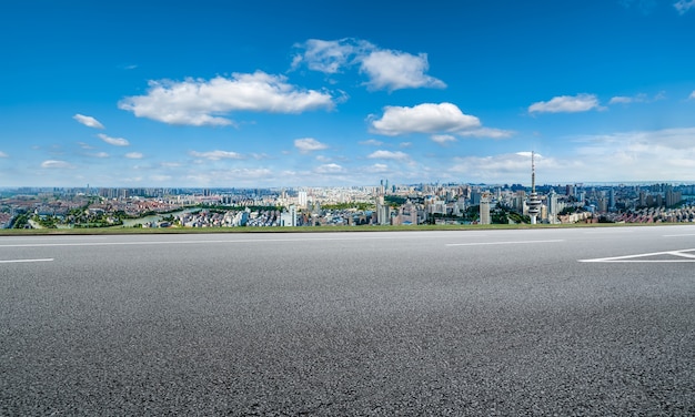 Panoramic skyline and empty asphalt road with modern buildings