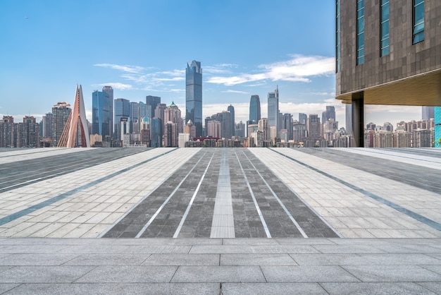 Panoramic skyline and empty square floor tiles with modern buildings