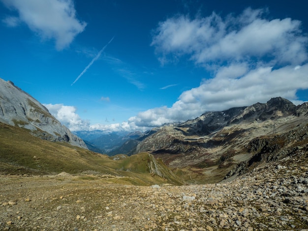 写真 曇った青い空の下で遠くの木質の山々の背景にパノラマの夏のビューグレリー自然なsu