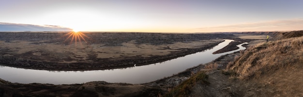 panoramic sunrise shot of desert like canyon with river, drumheller region alberta canada