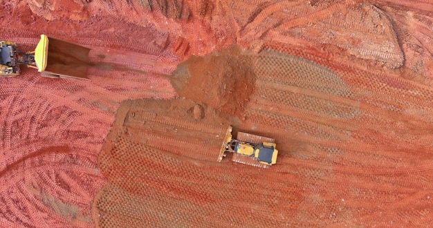 Панорамный вид сверху на ковшовый гусеничный экскаватор на земляных работах при погрузке, подъеме грунтовых работ на
