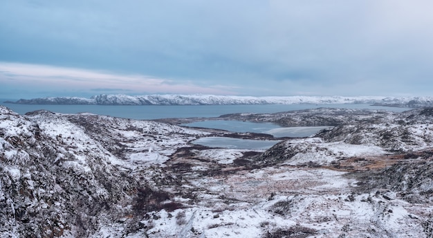 Panoramic view of Arctic winter mountain hard-to-reach lakes. Northern wildlife. Complex geological terrain.