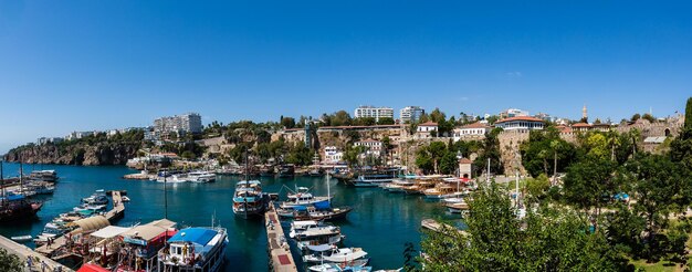 Photo panoramic view of boats moored in sea against clear blue sky