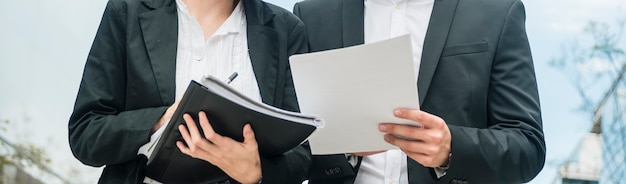 Panoramic view of businesswoman and businessman holding documents in the hands