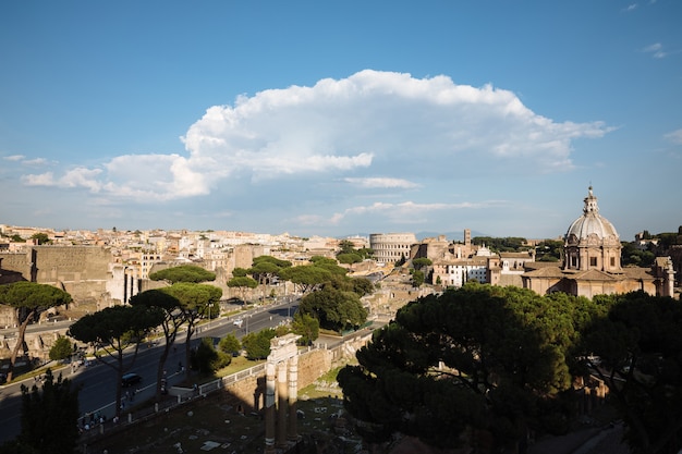 Panoramic view of city Rome with Roman forum and Colosseum from Vittorio Emanuele II Monument also known as the Vittoriano. Summer sunny day and dramatic blue sky