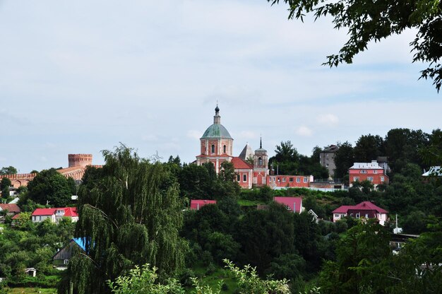 Panoramic view of the city. View of the old church and the fortress wall. Private houses among the trees.