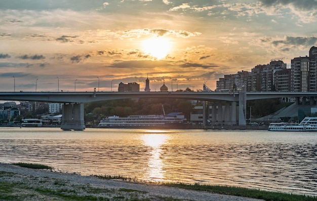 ドン川に架かる黄金の夕日ヴォロシロフ スキー橋と夜のロストヴォンドン市のパノラマ ビュー