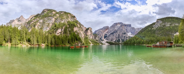 Panoramic view of the famous alpine lake Braies with a boat house and boats on the emerald surface of the lake