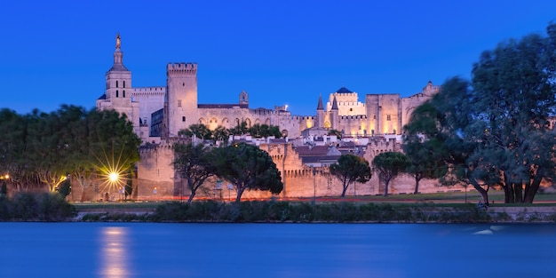 Photo panoramic view of famous medieval saint benezet bridge and palace of the popes during evening blue hour, avignon, southern france
