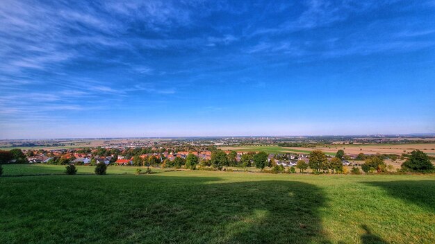 Panoramic view of field against blue sky