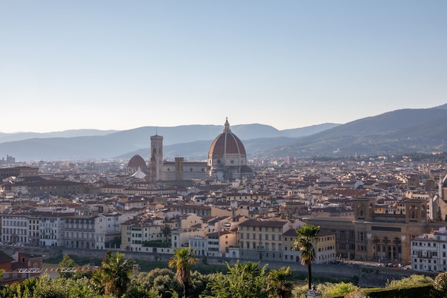 Panoramic view of Florence city with Cattedrale di Santa Maria del Fiore and Palazzo Vecchio from Piazzale Michelangelo (Michelangelo Square). Summer sunny day and dramatic blue sky