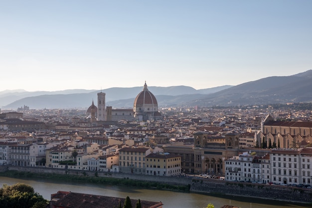 Vista panoramica della città di firenze con la cattedrale di santa maria del fiore e palazzo vecchio da piazzale michelangelo (piazza michelangelo). giornata di sole estivo e cielo blu drammatico