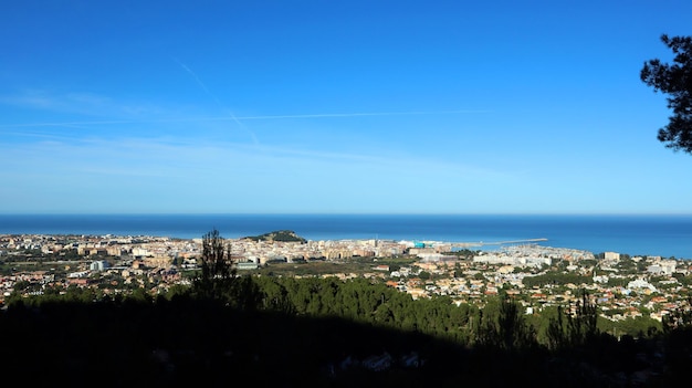 Panoramic view from height of Mediterranean resort seaside town Denia, roofs of the houses, sea