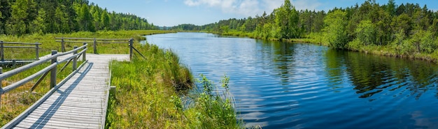 Photo panoramic view of the hiking trail with observation deck and lake during summertime