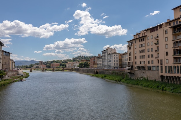 フィレンツェ市の歴史的中心部とイタリアの橋のあるアルノ川のパノラマビュー。夏の日と青い空。