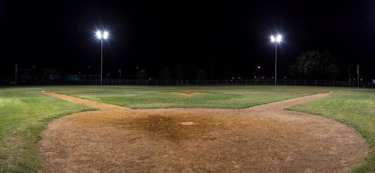 Photo panoramic view of illuminated baseball field against sky at night