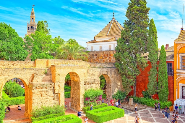 Panoramic view of inner patio Patio de la Monteria of the Royal Alcazar of Seville with tourists.