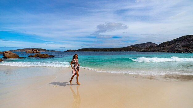 Photo panoramic view of little paradise beach in western australia with a girl in a dress walking