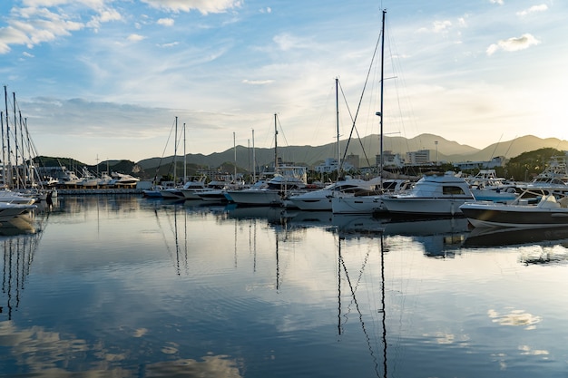 Panoramic view of luxury Marina with lots of sailboats on the dock during sunset.