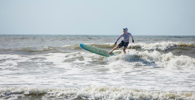 Panoramic view of middle aged man surfing in the Atlantic Ocean