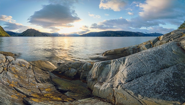 Panoramic view of norwegian fjord and rocks on foreground