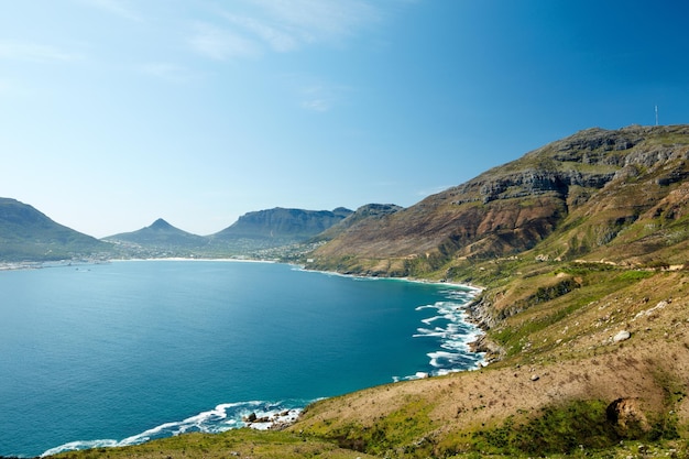 Panoramic view of the ocean surrounded by mountains from a hiking trail in Hout Bay Cape Town in South Africa Popular tourist attraction of hills and calm water against a blue sky with copyspace