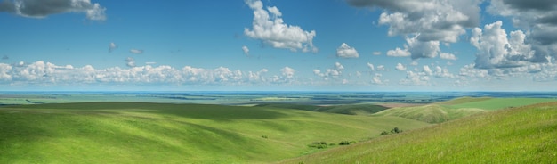写真 緑の草原と丘の山の夏の日のパノラマ景色