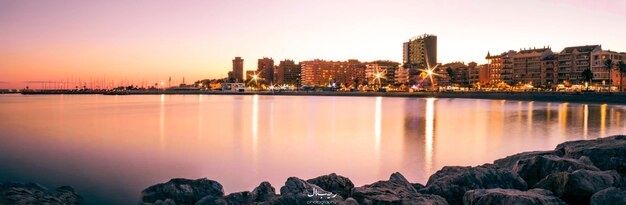 写真 夕暮れ の 時 に 照らさ れ て いる 都市 の パノラマ 景色