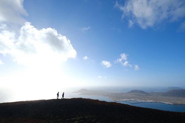 写真 空に照らして地面に立っている人々のパノラマ景色