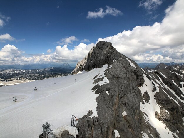 写真 空を背景に雪に覆われた山のパノラマ景色