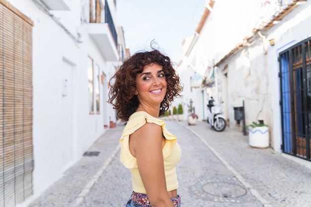 スペインの休日の女性のパノラマビュー。白いスペインの海岸の概念。旅行中の幸せな女性。