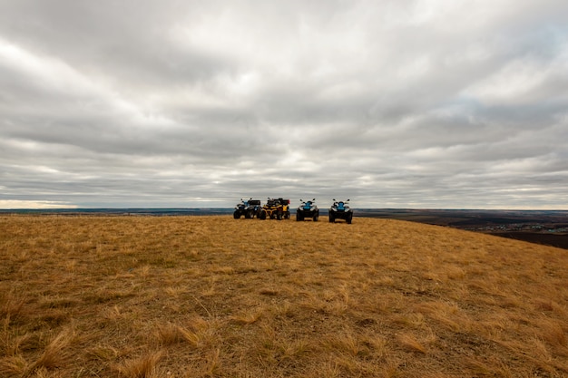 Panoramic view of Quad bikes in field on cloudy day