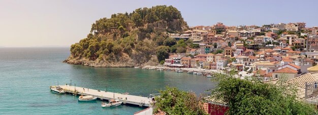 Panoramic view of the resort town of Parga pier sea and fortress in the distance on a sunny summer day region of Epirus Greece