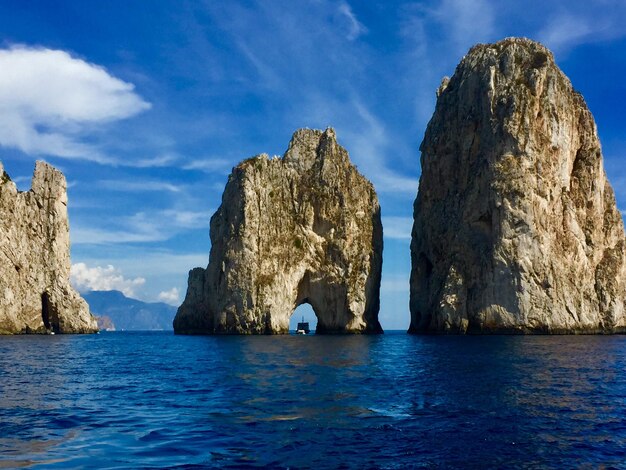 Panoramic view of rock formation in sea against sky