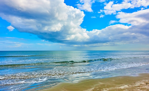 Panoramic view of a sandy beach, Mediterranean sea and white clouds in the sky - Seascape. Cyprus
