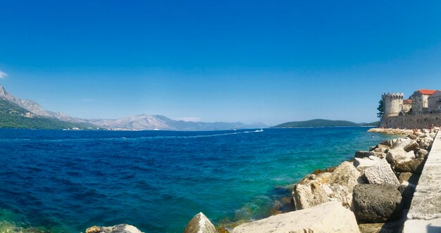 Panoramic view of sea against clear blue sky