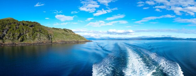 Panoramic view of sea and mountains against blue sky