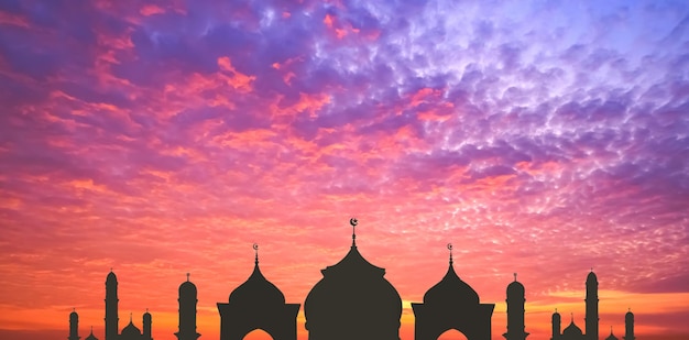 Panoramic view of silhouette mosque domes with towers against colorful sunrise sky illustration